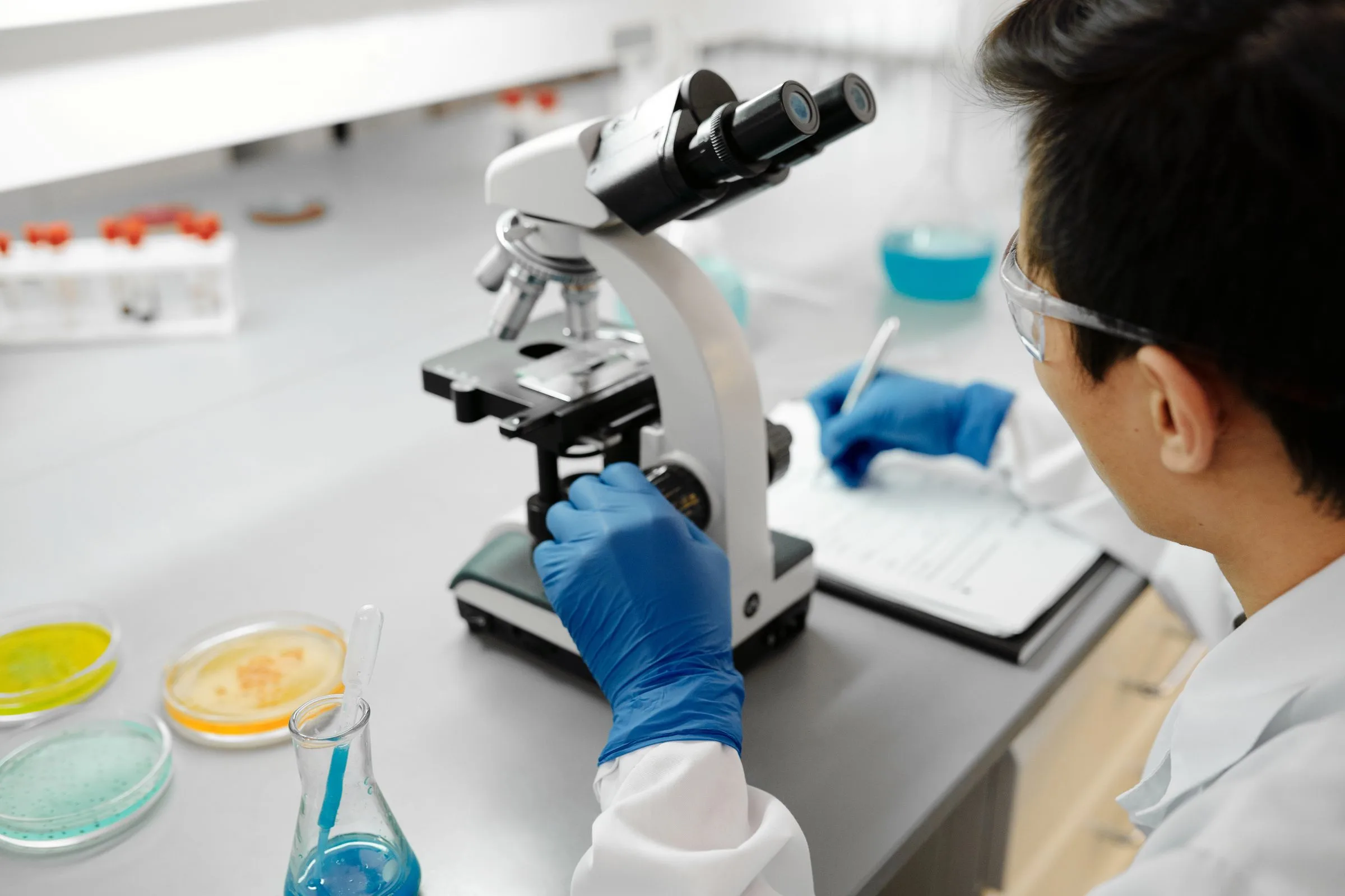 Peneliti menggunakan mikroskop di laboratorium