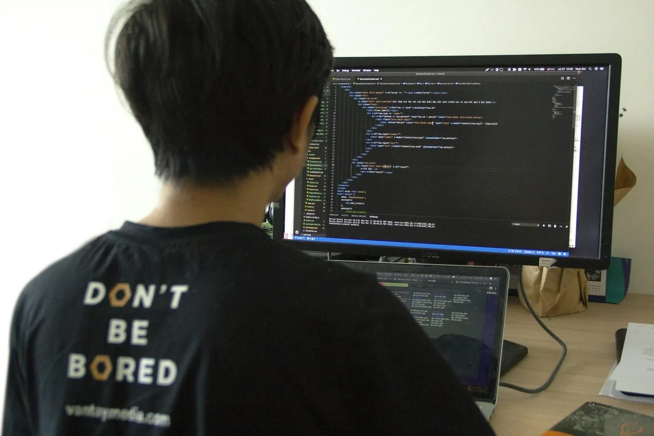 Programmer menulis kode di depan monitor