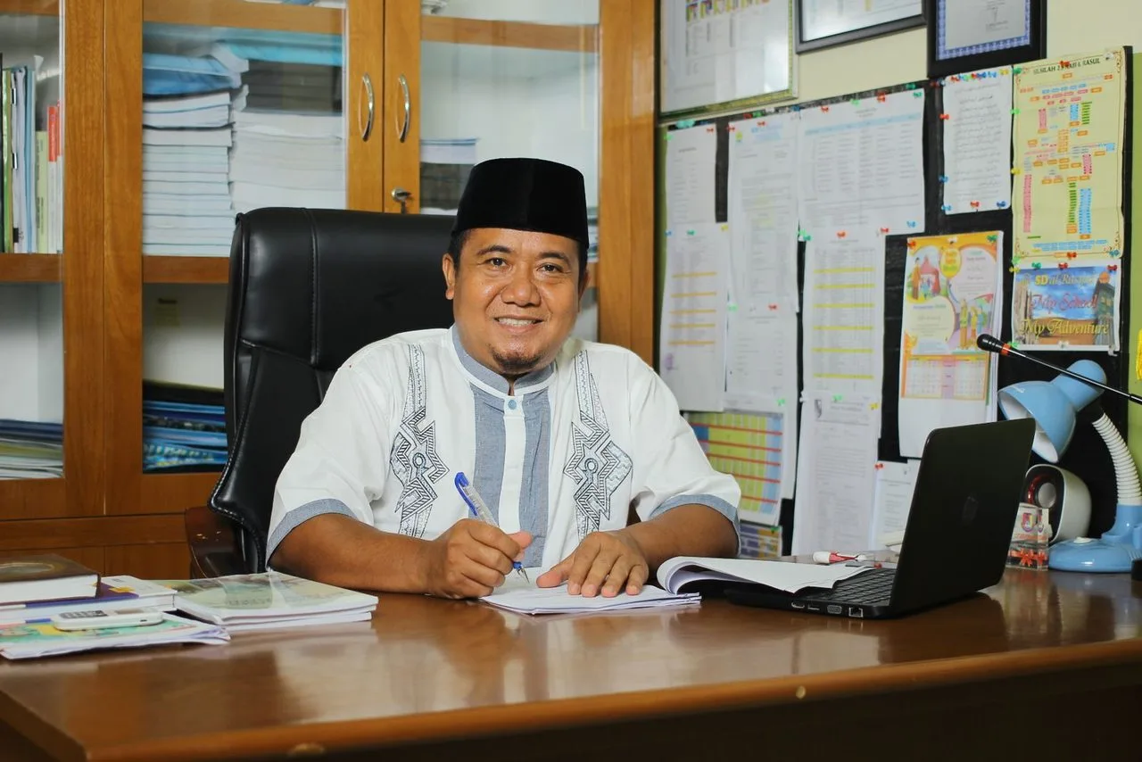 Pegawai tersenyum di meja kerja kantor dengan dokumen
