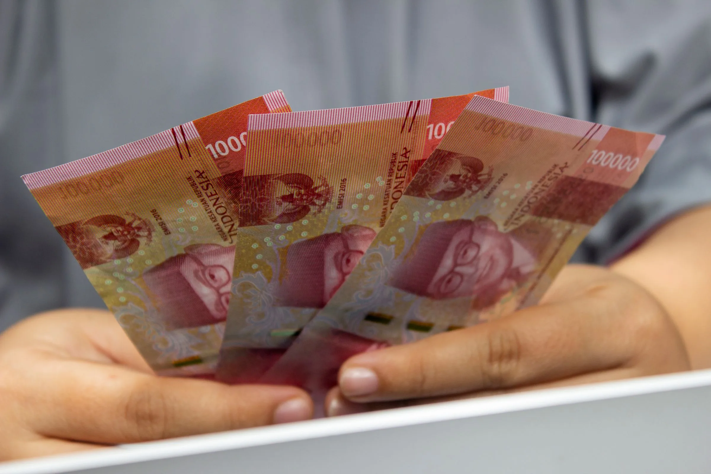 Tangan memegang uang kertas rupiah
